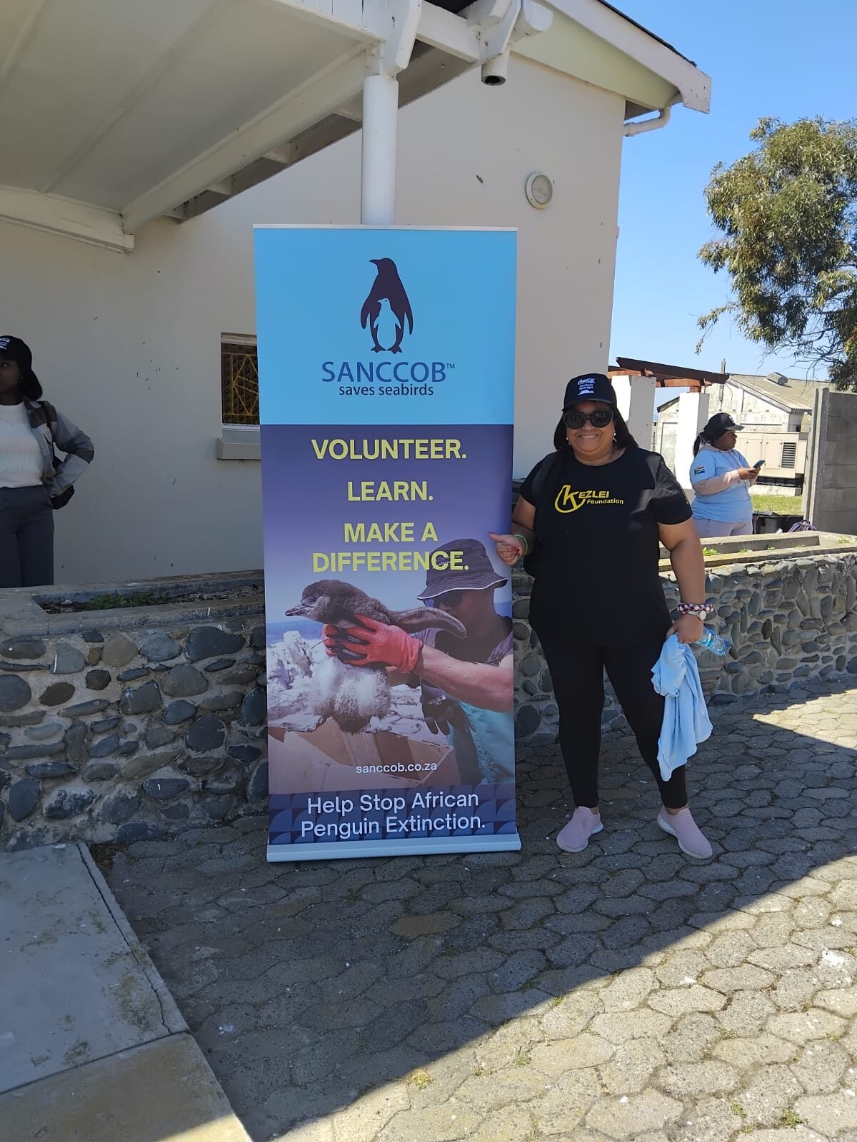 A Kezlei volunteer at the SANCCOB volunteer banner