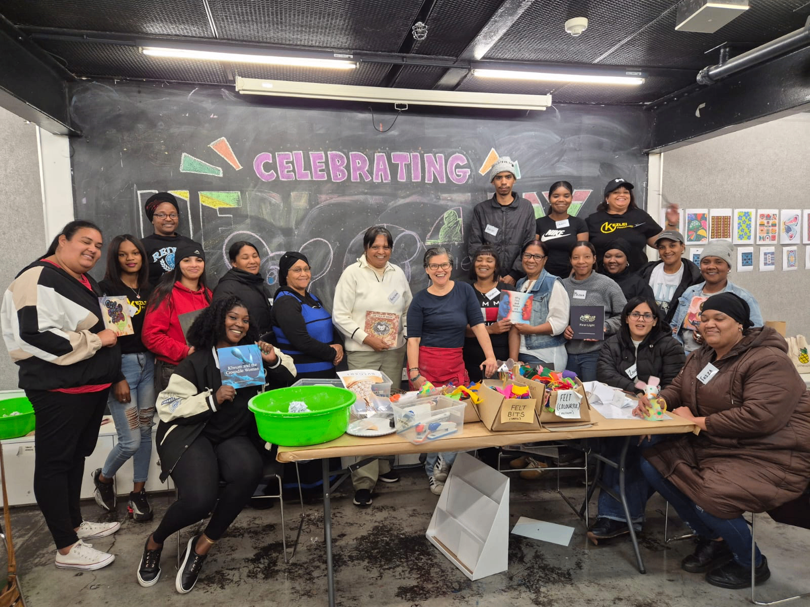 Kezlei’s new group of reader volunteers gathered around a table with books and craft materials